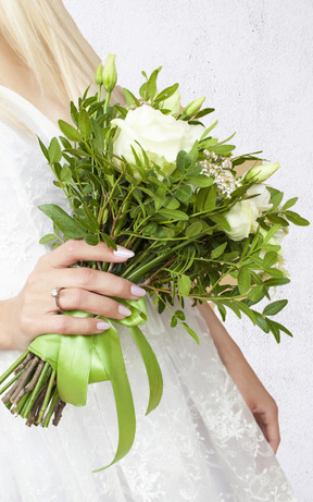 Uma mulher em um vestido branco, segurando um buquê de flores