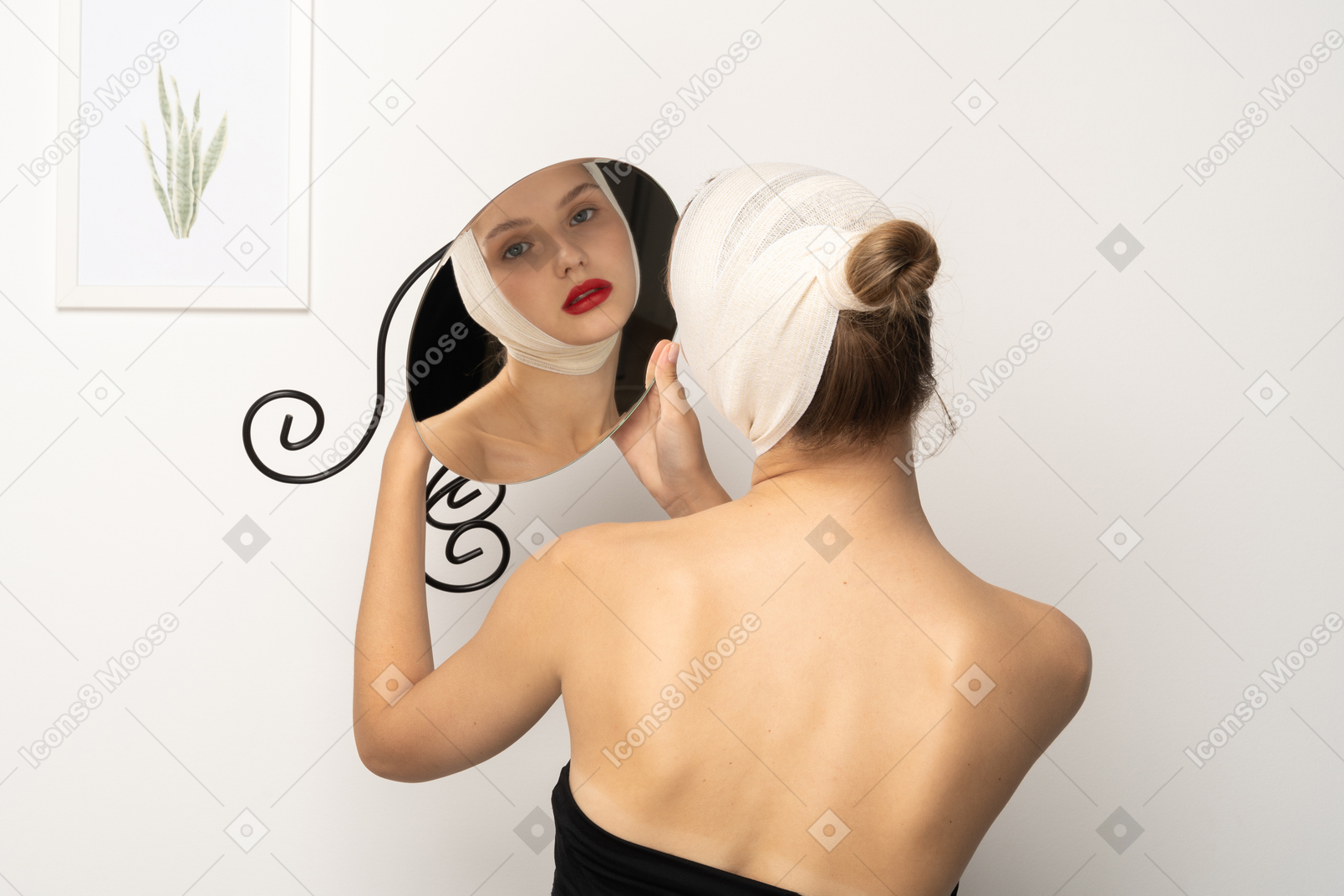 Young woman with bandaged head holding up a mirror