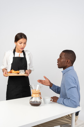 Cliente insatisfeito dizendo uma garçonete por estragar o seu pedido