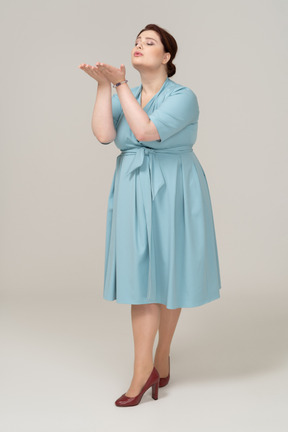 一个穿着蓝色裙子的女人在亲吻的前视图