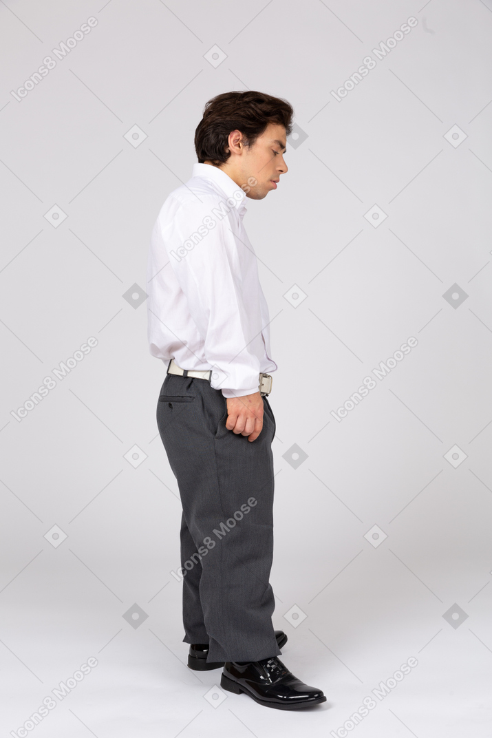 Vista laterale di un uomo in abiti casual business guardando verso il basso