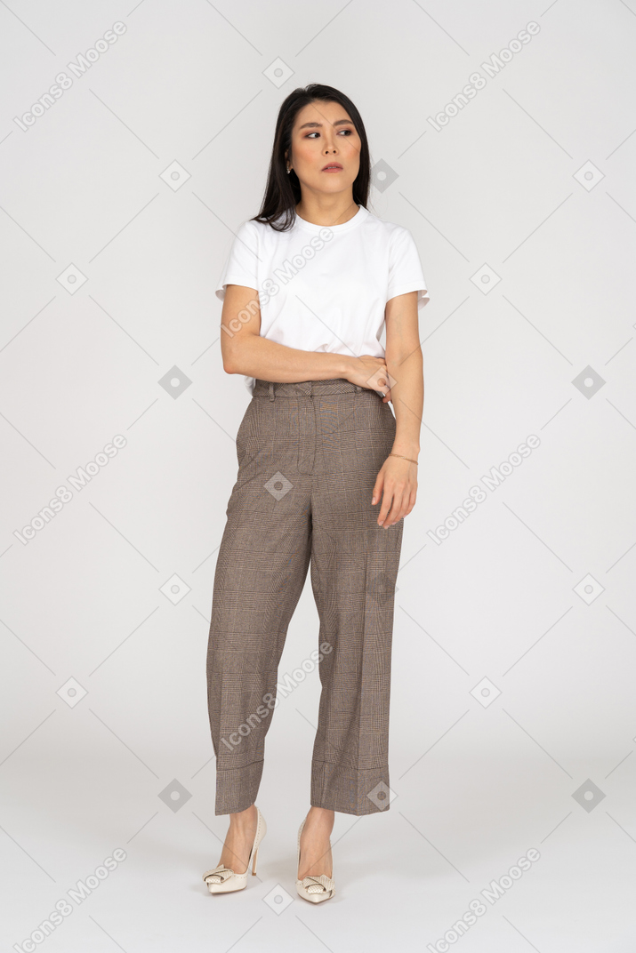 Front view of a displeased young lady in breeches and t-shirt