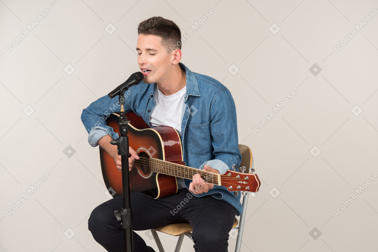 프로필 테이블에 앉아 기타 연주 젊은 남자