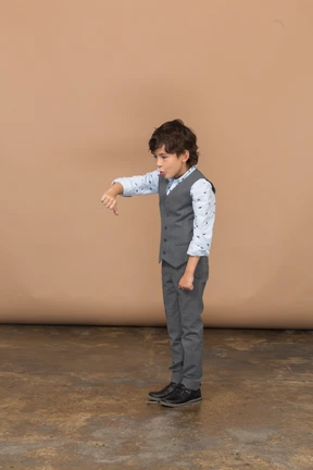 Side view of a boy in grey suit showing thumb down
