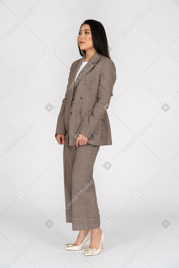 Three-quarter view of a young lady in brown business suit