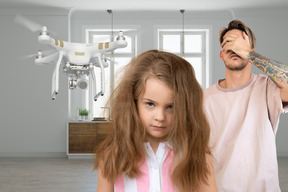 Man and little girl standing in front of drone