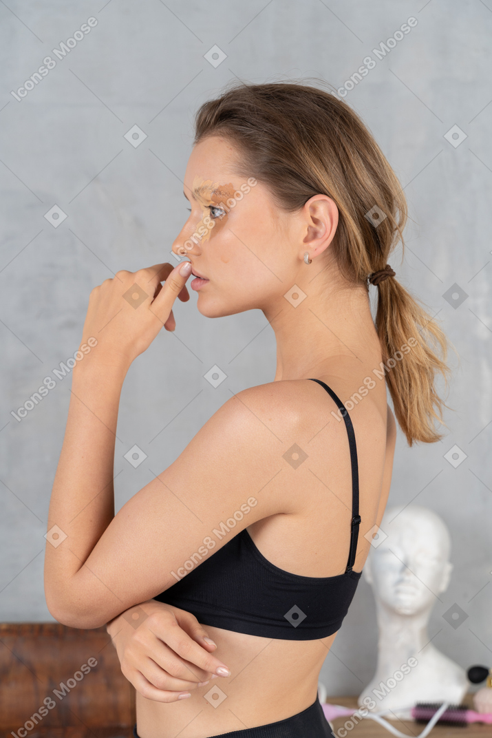 Vista lateral de uma mulher pensativa com maquiagem dos olhos