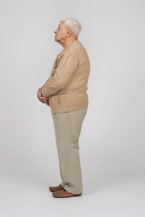 Old man in casual clothes standing in profile