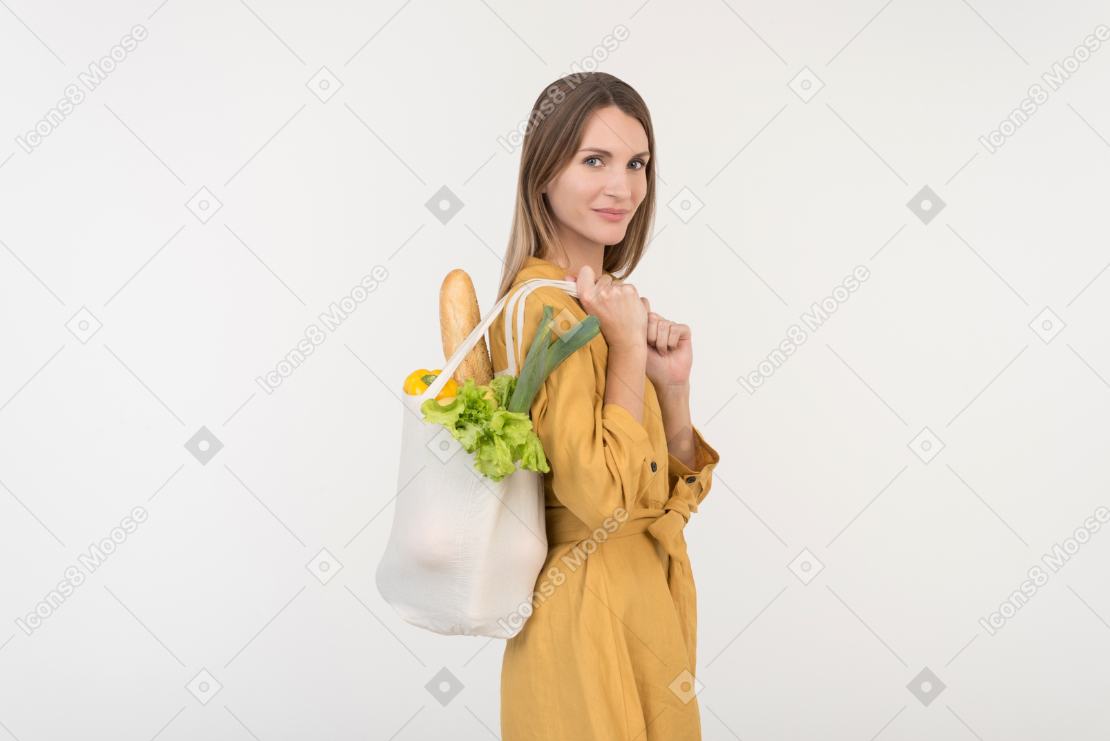 야채와 함께 쇼핑 가방을 들고 아래를 내려다 보면서 젊은 여자