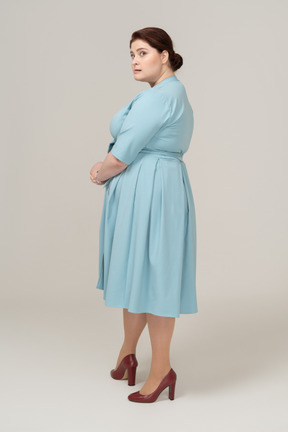 Donna in abito blu in posa di profilo
