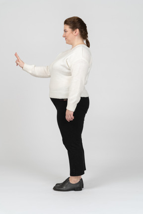 Plump woman in casual clothes standing in profile