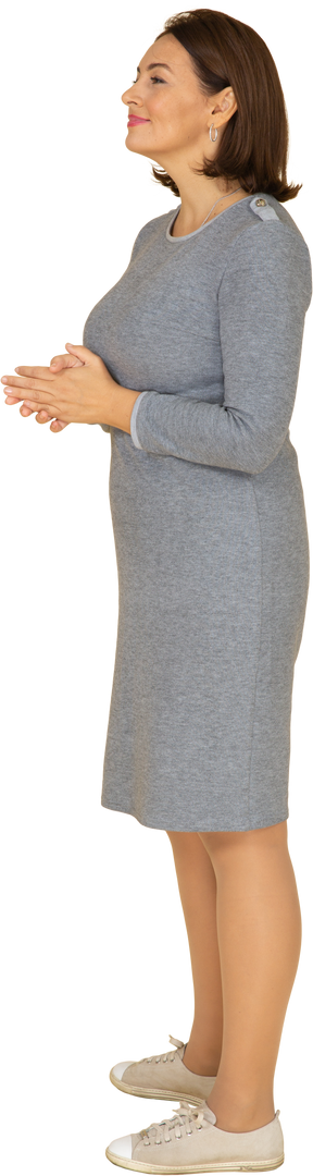 一个穿着灰色裙子摆姿势的女人的侧视图