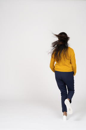 Rear view of a girl in casual clothes running