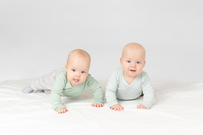 Curious babies twins lying on the stomach