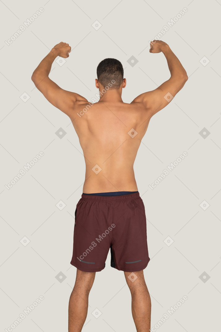 Вид сзади сильного мужчины, показывающего свои бицепсы