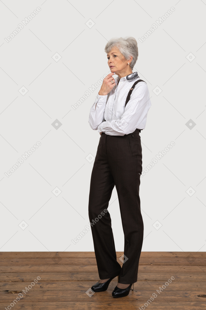 Three-quarter view of a thoughtful old lady in office clothing touching her chin