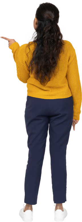 Rear view of a girl in casual clothes pointing with finger