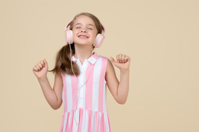 Cute little girl in the headphones listening to a music