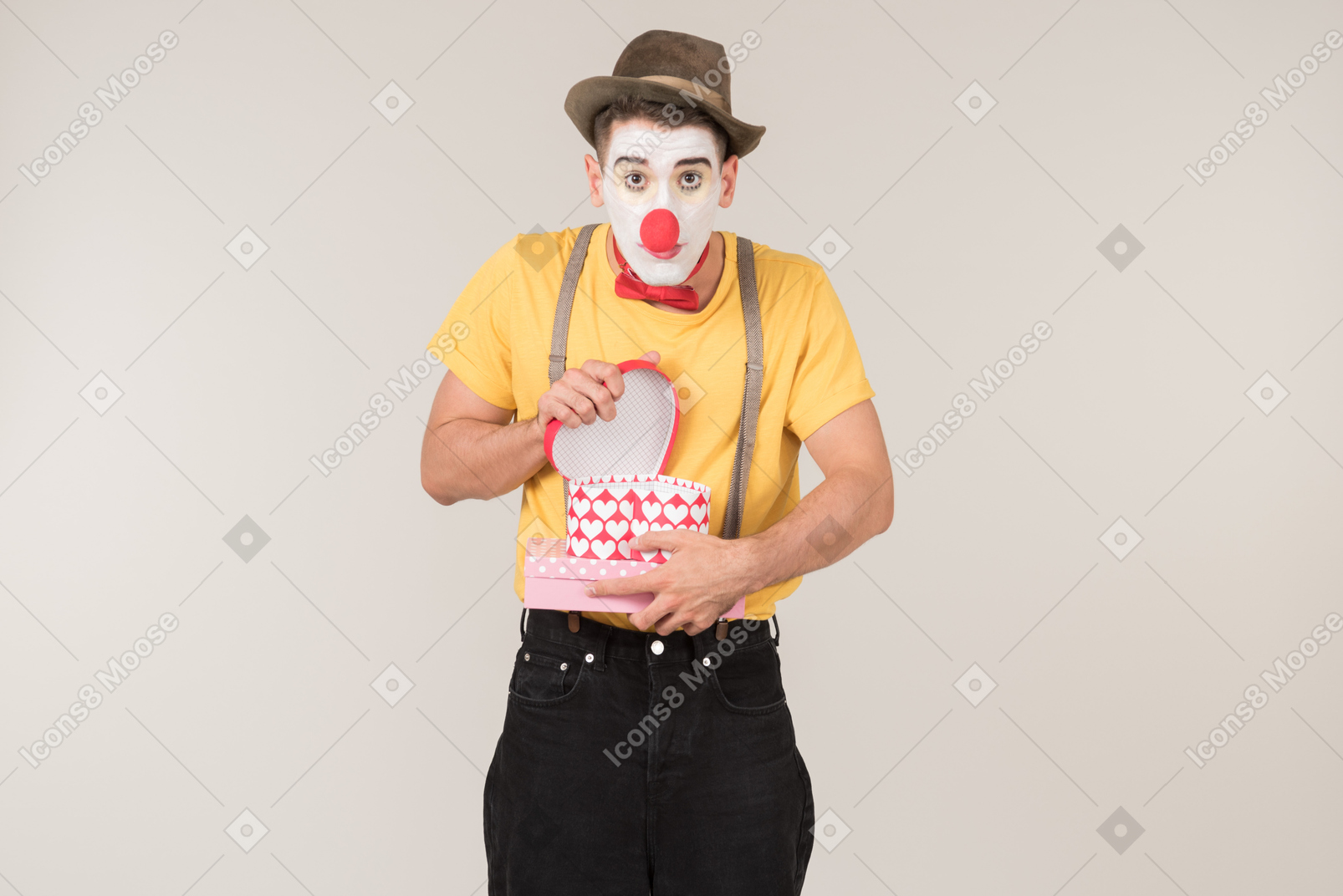 Sad male clown holding empty gift box