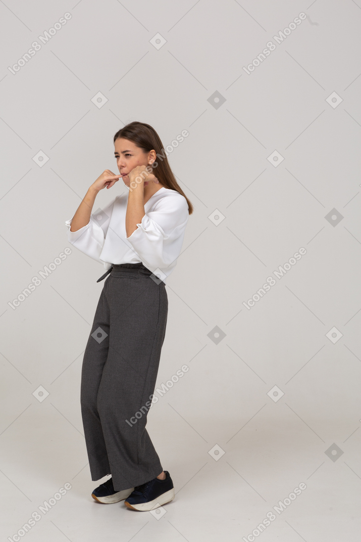 Three-quarter view of a whistling young lady in office clothing