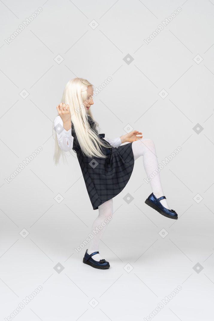 Side view of a schoolgirl kicking her feet