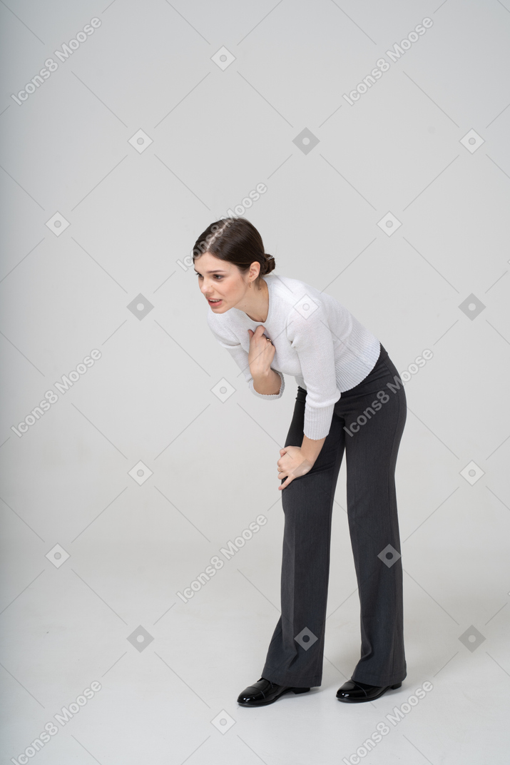 Front view of a young woman in suit bending down and arguing with someone