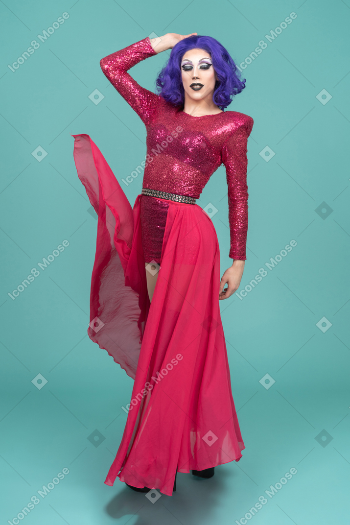Drag queen in pink dress posing with hand on top of head