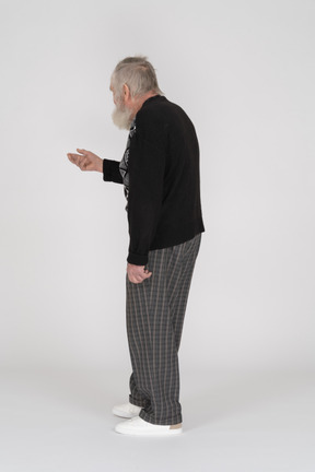 Vista posteriore di un uomo anziano che allunga la mano