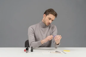 A young man arranging his nails