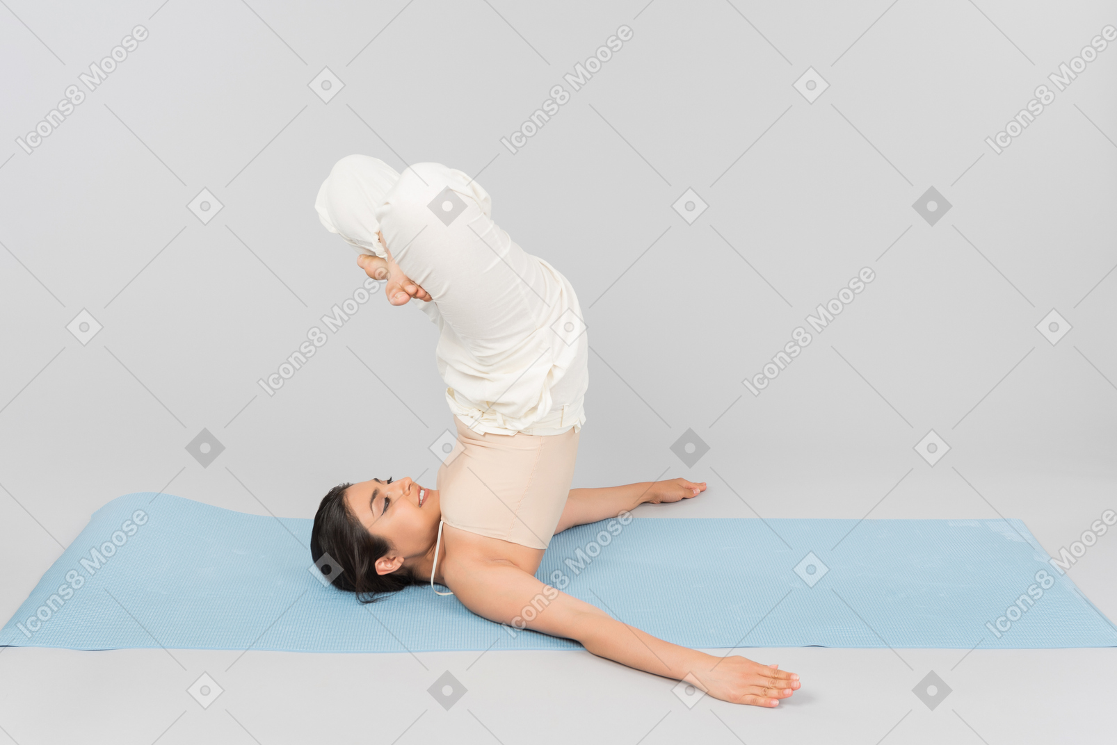 Молодая индийская женщина, лежа на голове на коврик для йоги