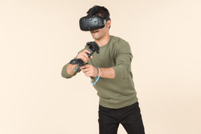 Young caucasian guy playing a virtual reality game