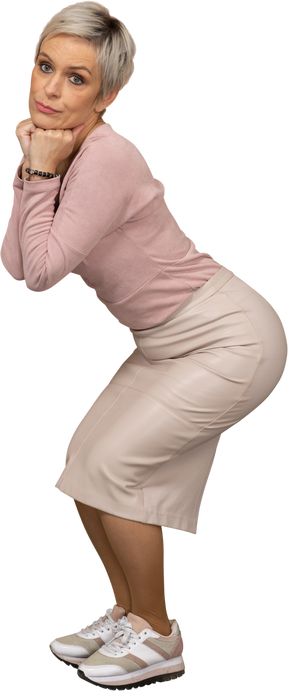 Vista lateral de uma mulher com roupas casuais agachada