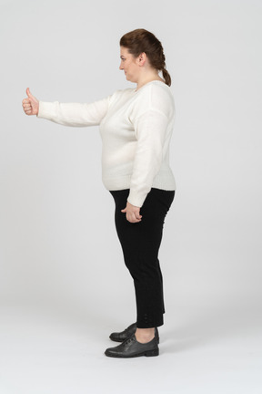 Mujer regordeta en ropa casual mostrando el pulgar hacia arriba