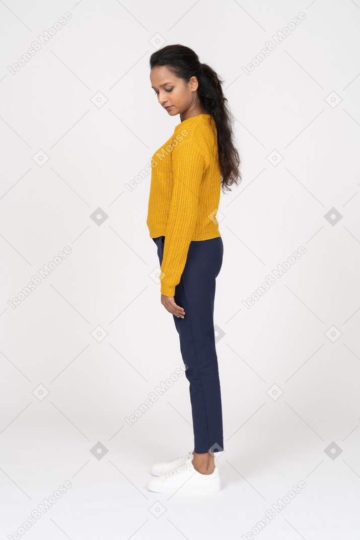Side view of a beautiful girl in casual clothes looking down