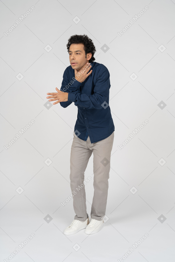 Front view of a man in casual clothes chocking himself and gesturing