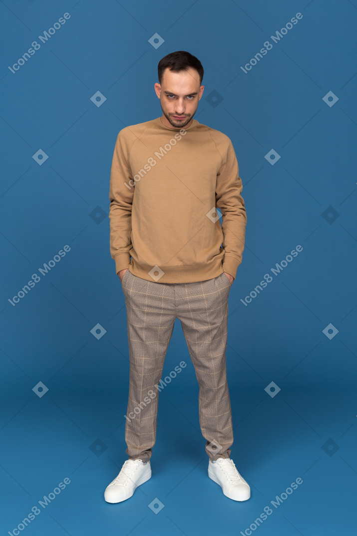 Young man standing with hands in poclets
