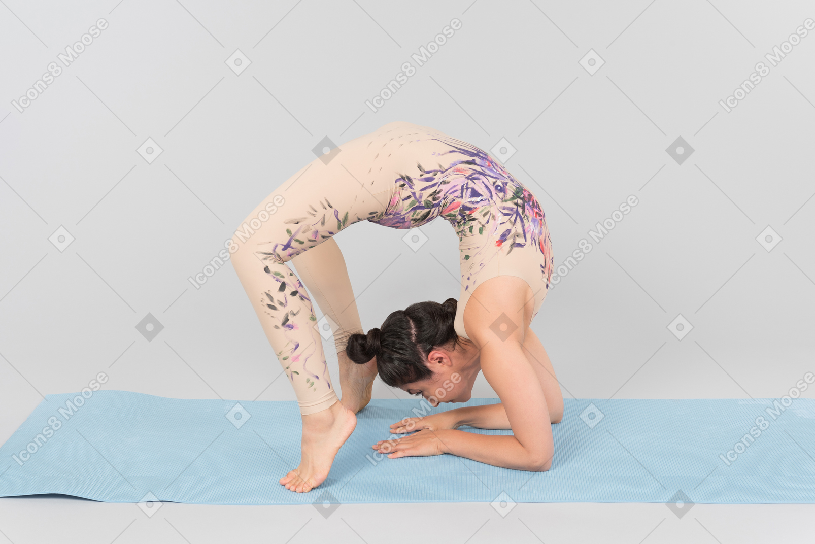 Joven mujer india de pie sobre la estera de yoga en sus manos