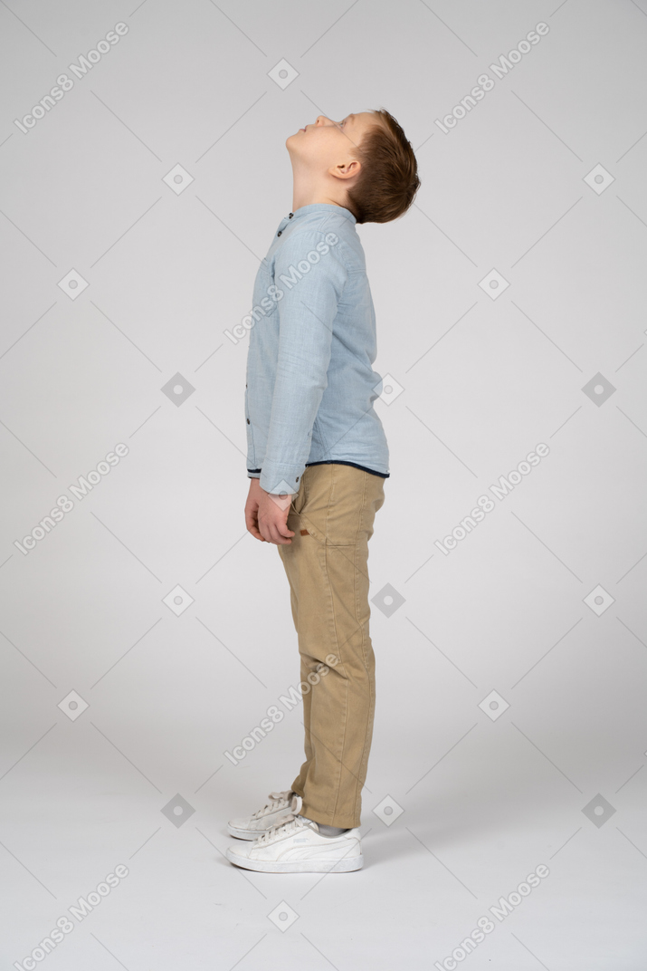 Vista lateral de un chico lindo mirando hacia arriba