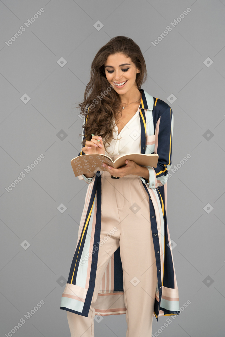 Cheerful female writer with a notebook