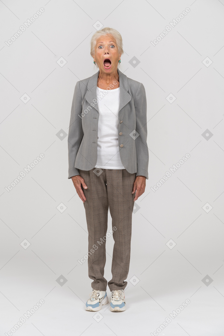 一位身穿西装、张大嘴巴站立的老妇人的前视图