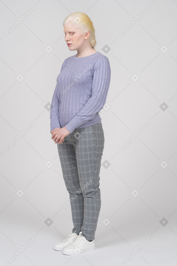 Young woman in casual clothes looking down