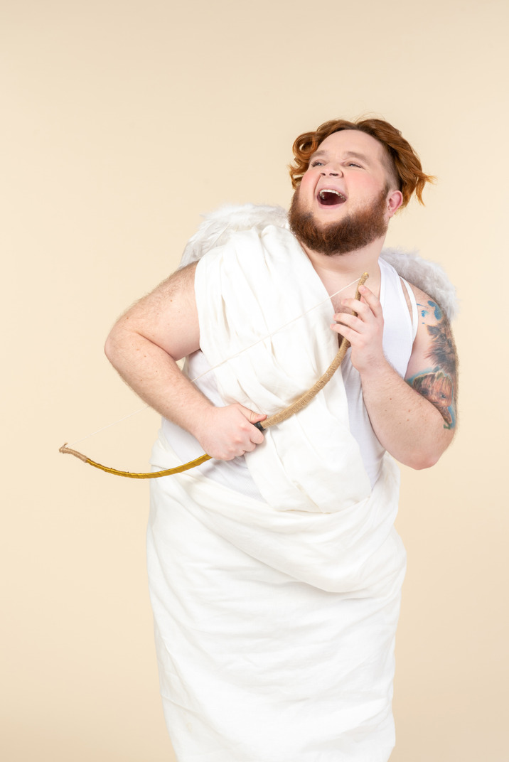Laughing big guy dressed as a cupid holding bow