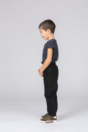 Vista lateral de un chico lindo en ropa casual haciendo muecas