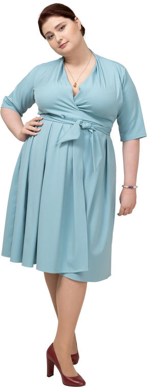 Vista frontale di una donna in abito blu in posa con la mano sull'anca
