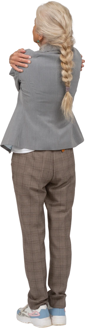 Back view of an old lady in suit hugging herself