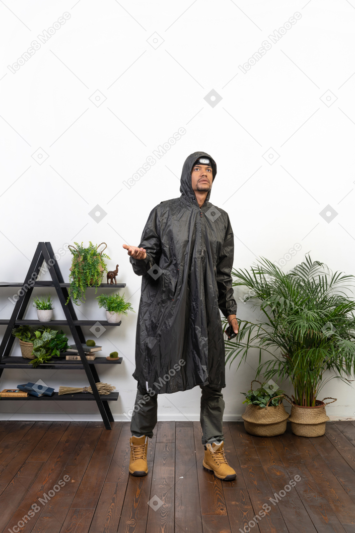 Man in raincoat checking if it's raining