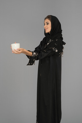 Young muslim woman holding a white cup