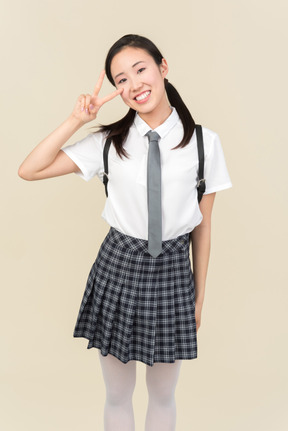 Asian school girl showing v sign