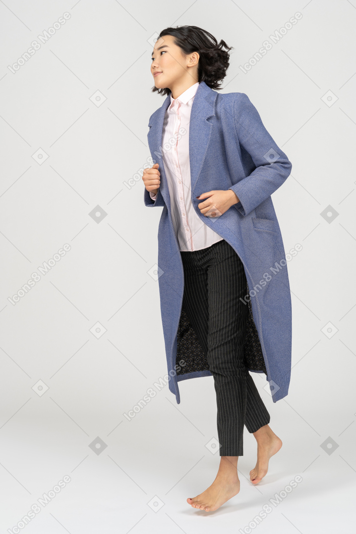 Счастливая женщина в пальто бежит
