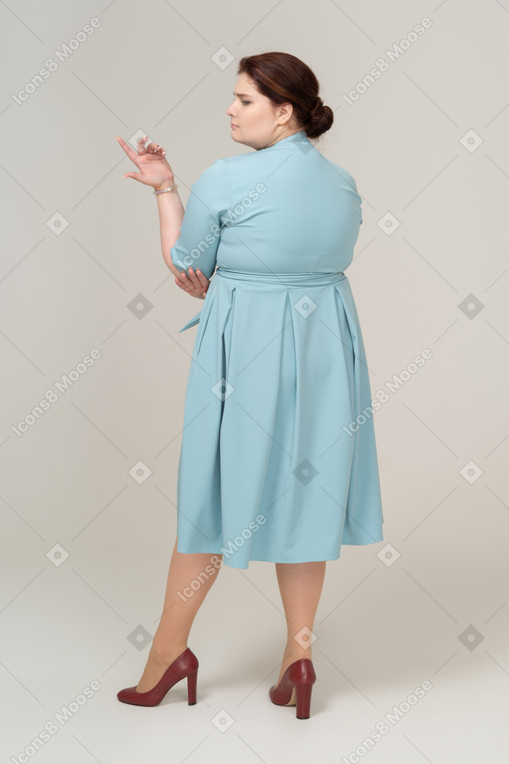 Rear view  of a woman in blue dress posing